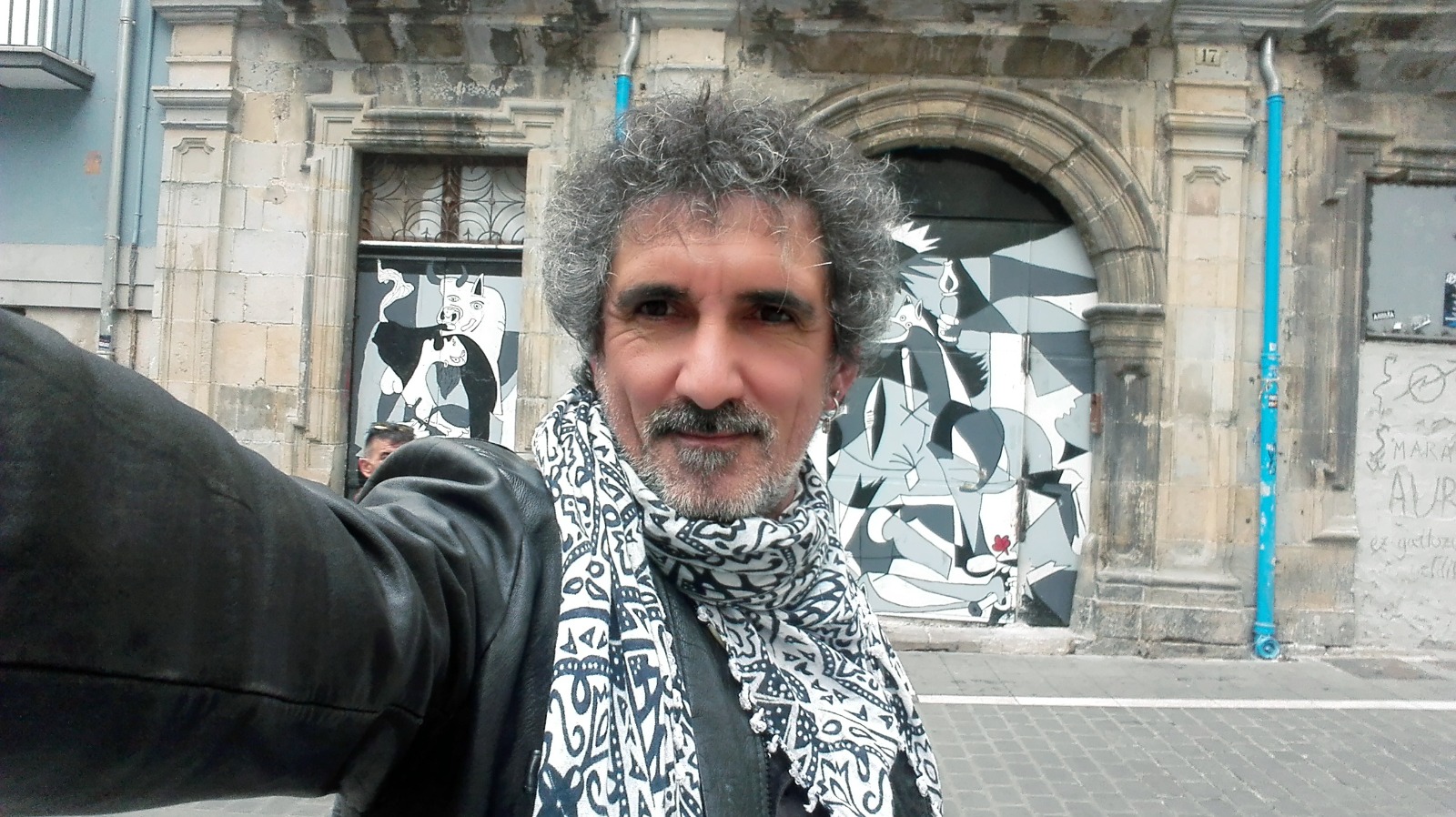 Romero Bey, frente a un mural del Guernica. 